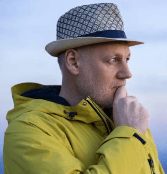 Nice Guy Syndrome: Are You Falling Into This Trap? 62 A Thoughtful Man In A Yellow Jacket And Hat, Looking Into The Distance, Symbolizing Self-Reflection And Taking The First Steps To Overcome Nice Guy Syndrome.