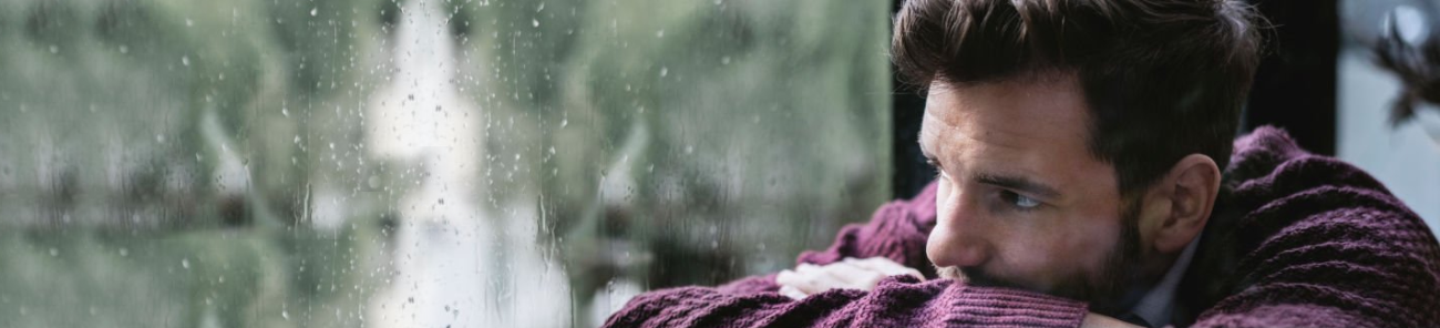Nice Guy Syndrome: Are You Falling Into This Trap? 59 A Man In A Sweater Leaning Against A Window On A Rainy Day, Lost In Thought, Symbolizing Introspection And Recognizing The Signs Of Being A Nice Guy