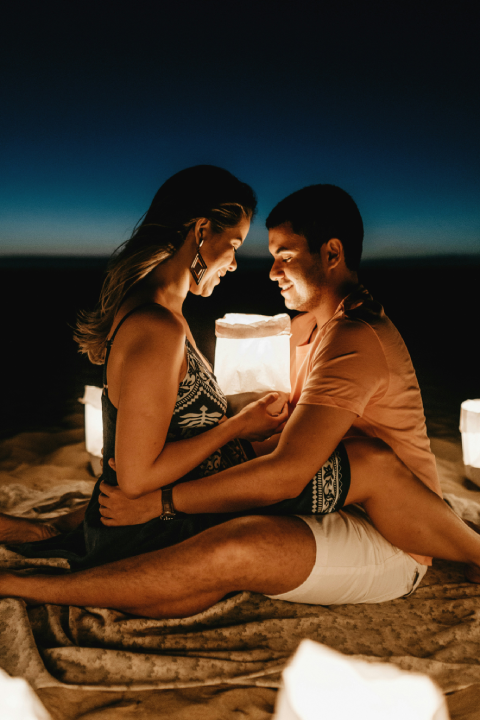 How To Build Sexual Tension With A Woman On A Date 50 A Couple Sitting Closely On The Beach At Night, Gazing Into Each Other'S Eyes, Using Deep Eye Contact And Body Language To Build Sexual Tension In A Romantic Setting.