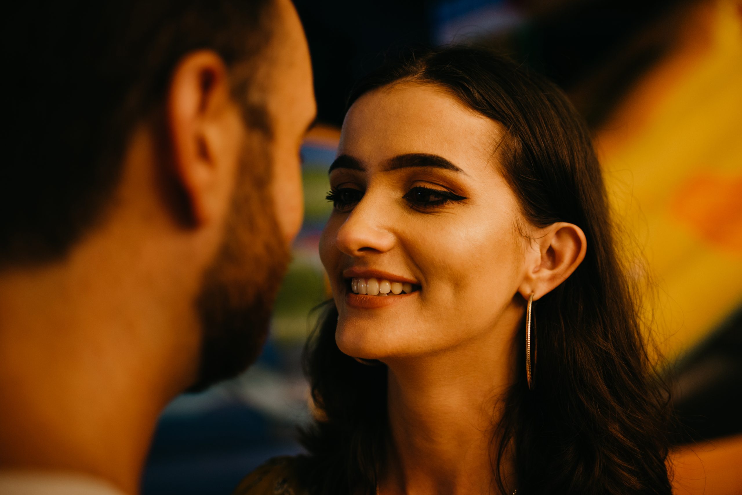 Why Qualifying Women Boosts Attraction - And How To Do It Naturally 27 Why Qualifying Women Boosts Attraction - A Close Portrait Of A Woman In A Yellow Dress With A Plunging Neckline Who Is Admiring Her Boyfriend With A Beard Near Amusement Rides. A Couple Of Lovers On A Date At The Fair In Valencia.