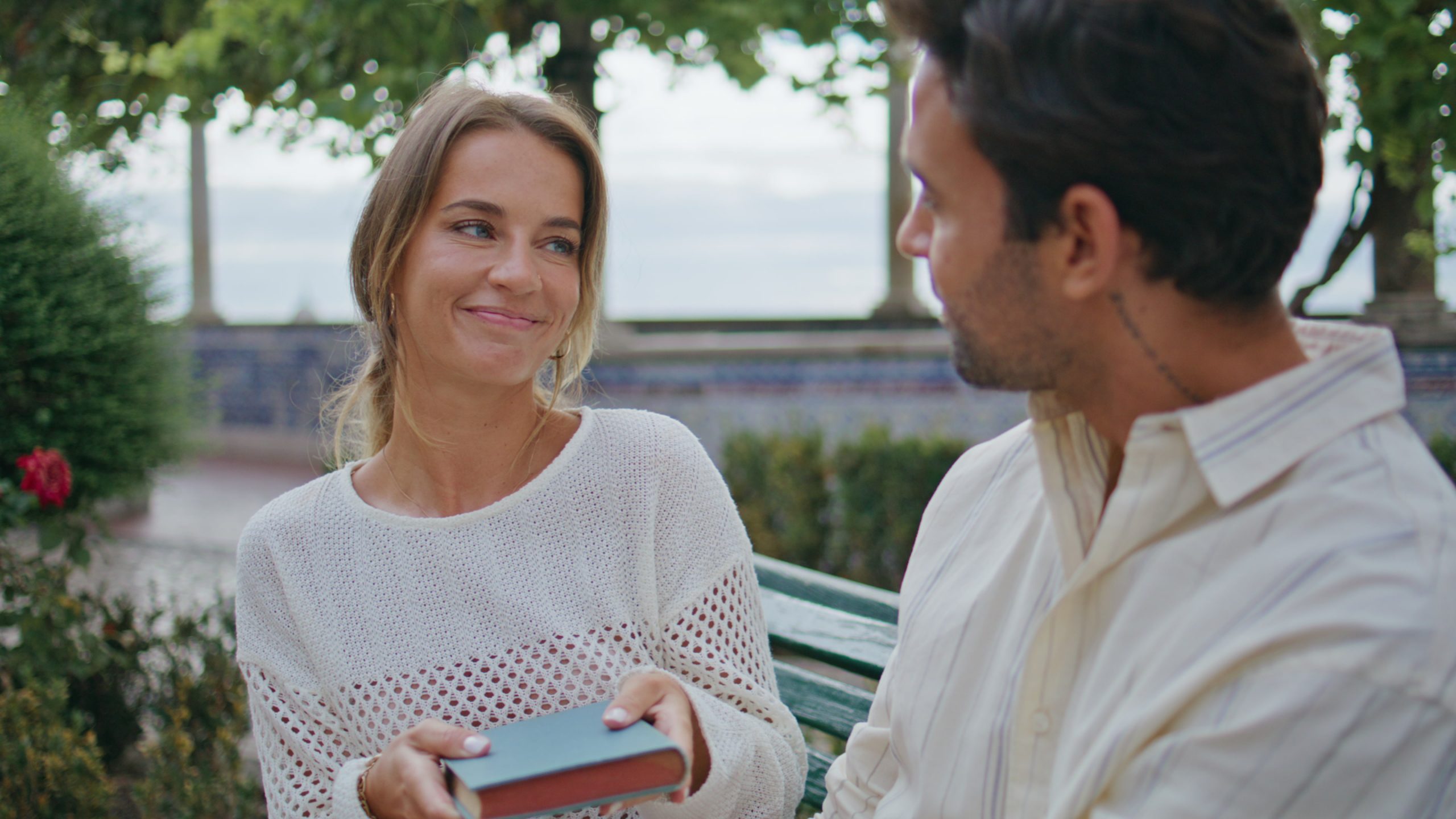 How To Friend Zone A Girl (Without Ruining The Vibe Or Losing Power) 15 How To Friend Zone A Girl - Cute Woman Giving Present To Loving Boyfriend At Seaside Bench Closeup. Happy Bearded Man Taking Book Feeling Surprised At Romantic Date. Smiling Lovers Kissing Each Other Embracing At Summer Park
