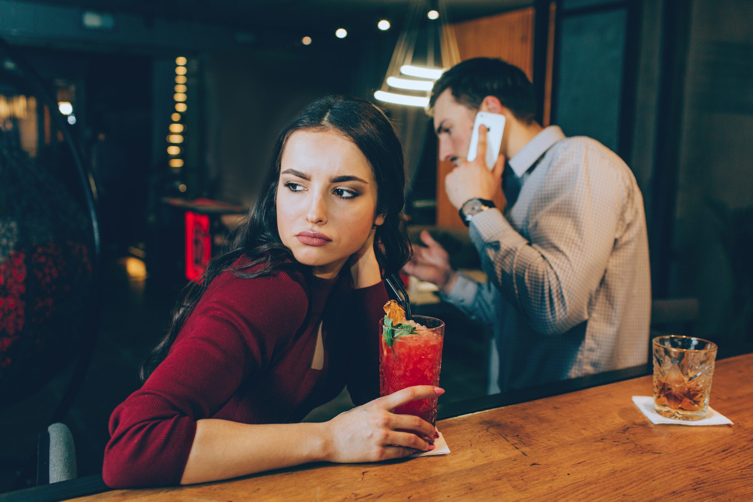 Why Ignoring A Woman Works (And Why It’s Dangerously Addictive) 25 Why Ignoring A Woman Works - Sad Picture Of Girl Looking To The Right. She Is Sad Because Man Is Answering To The Phone Call And Not Spending Time With Her. She Doesn'T Have A Good Mood