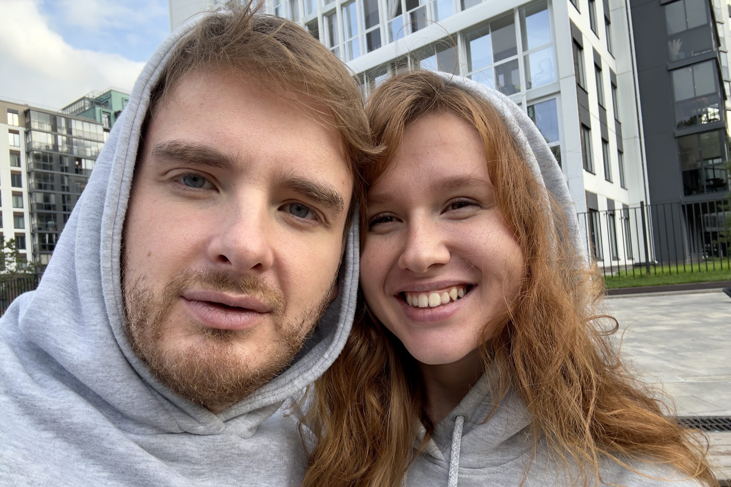 Why Beautiful Women Marry “Unattractive” Men: The Truth About Female Psychology 22 Why Beautiful Women Marry “Unattractive” Men - Smiling Young Couple Looking At Screen Of Mobile Phone While And Taking Selfie Against City Buildings, Concept Love, Young Family