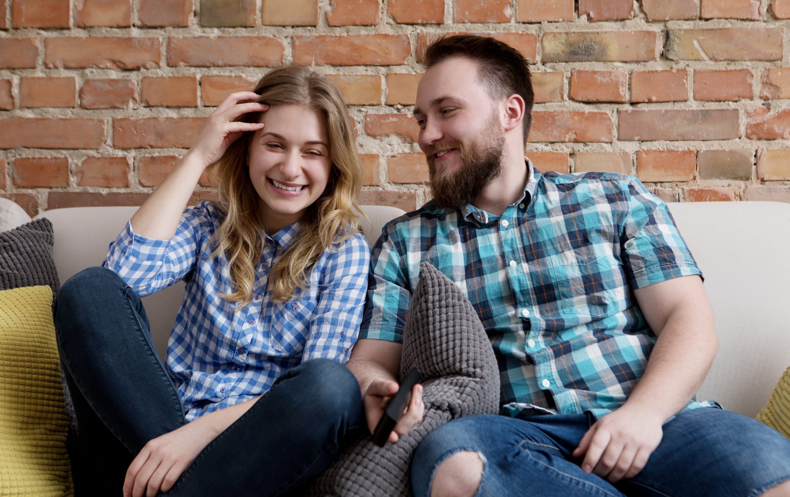 Nice Guy Behavior Patterns That Women Secretly Despise 20 Nice Guy Behavior Patterns - Young Woman And Man Sitting On Sofa And Watching Tv.