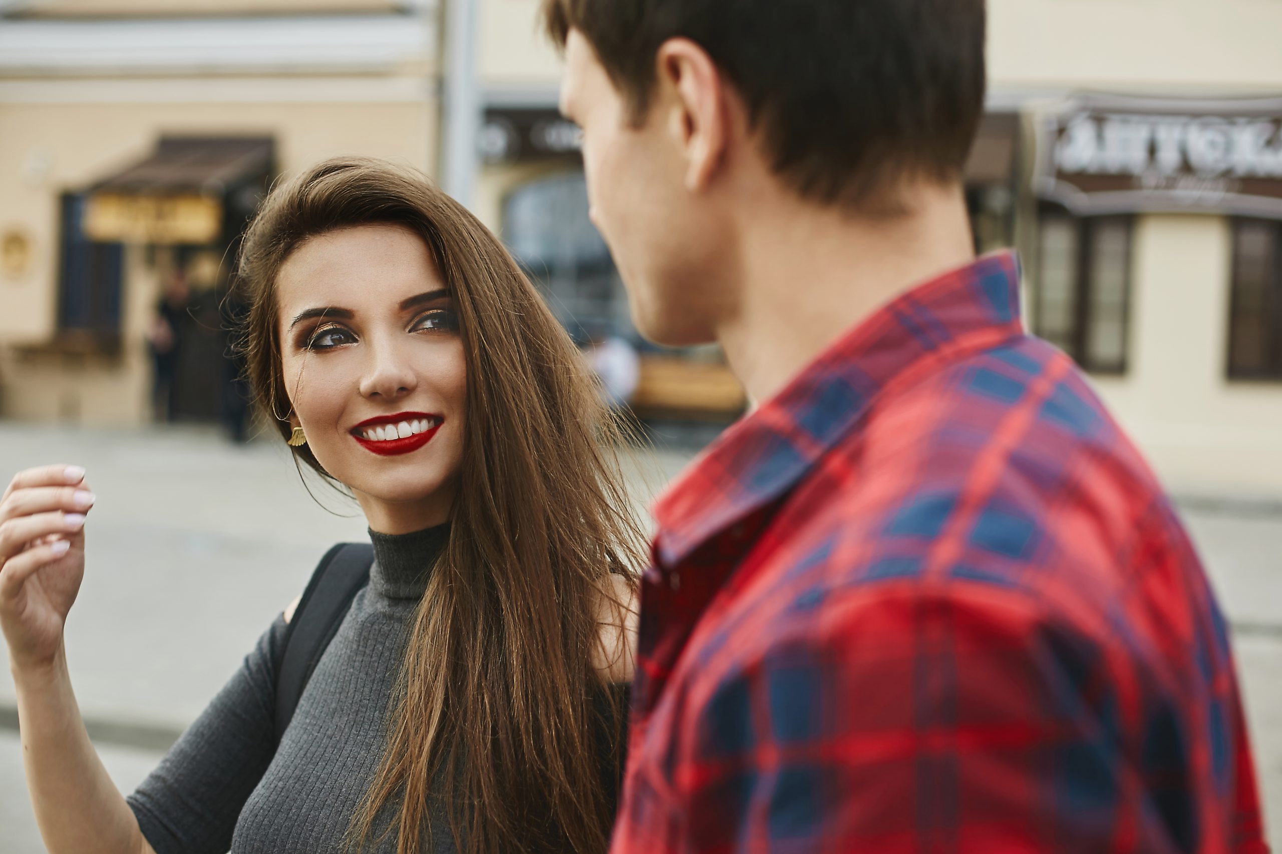 How To Get A Woman’s Attention Using Intrigue (Without Being Obvious) 24 Get A Woman’s Attention Using Intrigue - Young Beautiful Couple Of Lovers At The Dating. Young Woman With A Perfect White Smile And Red Lips And A Handsome Young Man Spending Time Together In The City.